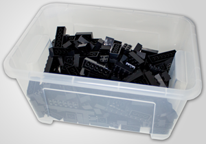 Ikea© plastic box filled with black Lego® Bricks